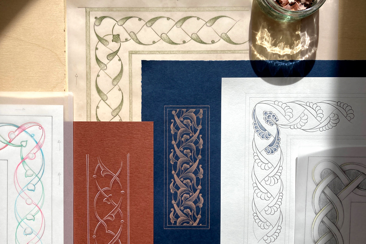 A styled flat-lay of several patterned paper sheets with Celtic knot and scroll designs in different colors, including cream, navy blue, rust red, and white, arranged on a beige surface with a glass jar partially visible at the top right.