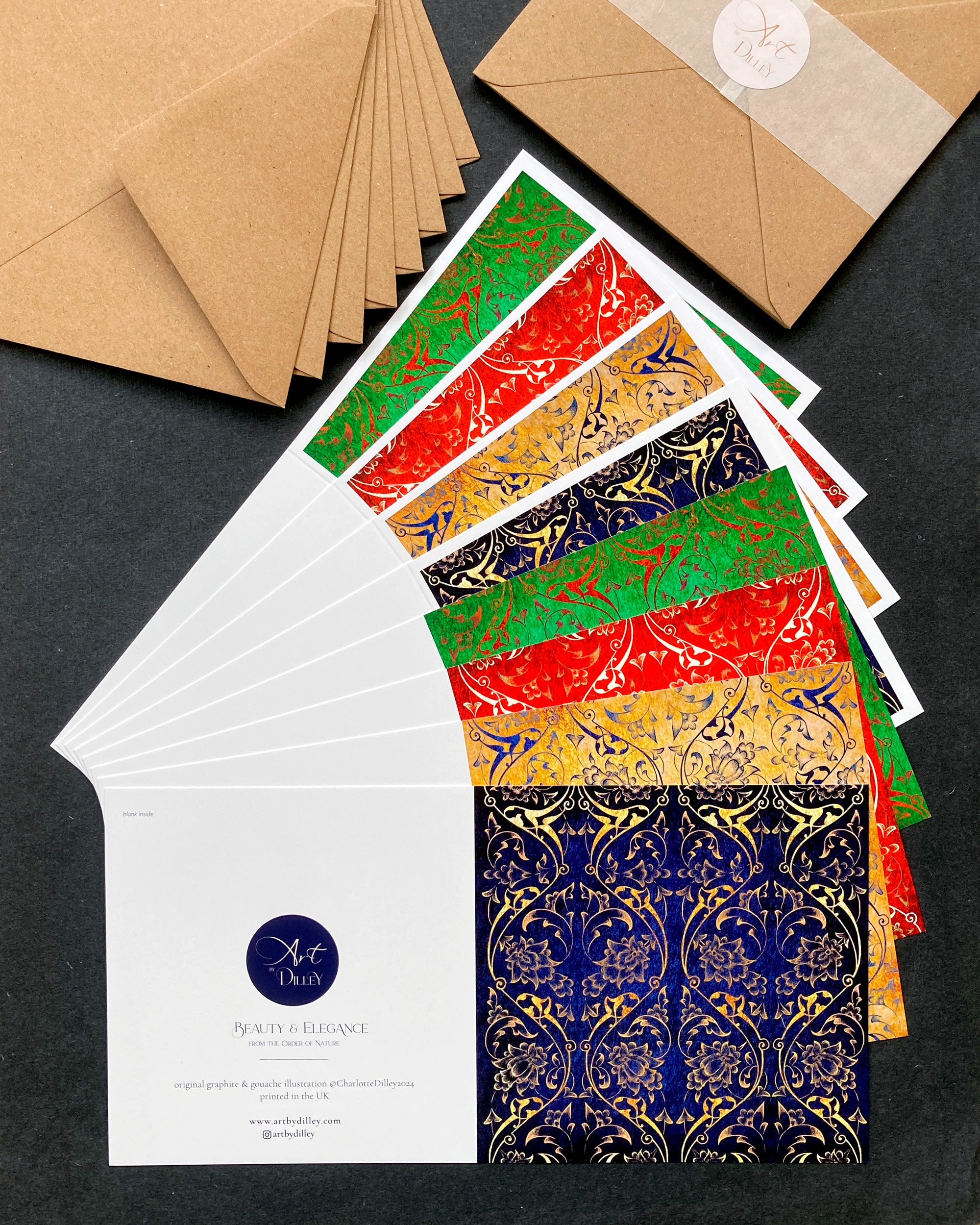 Flat lay of 8 square christmas cards in green, red, blue and yellow ornamental pattern and kraft envelopes