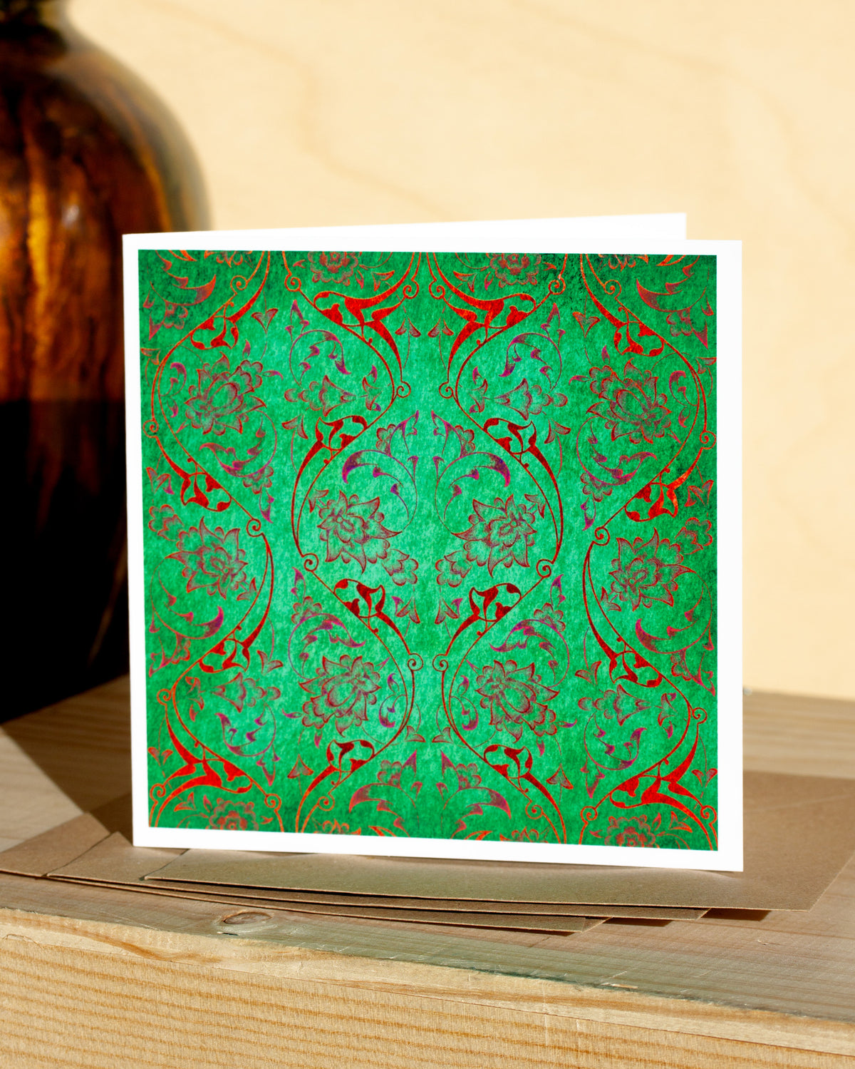 Square, green and red christmas card with ornamental pattern and white border